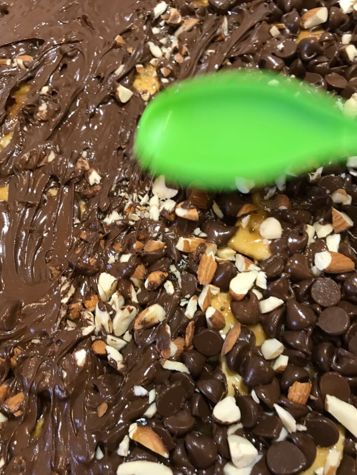 With the back of a silicone spoon or spatula, gently spread out the softened chocolate, pressing the almonds into the chocolate as you go.