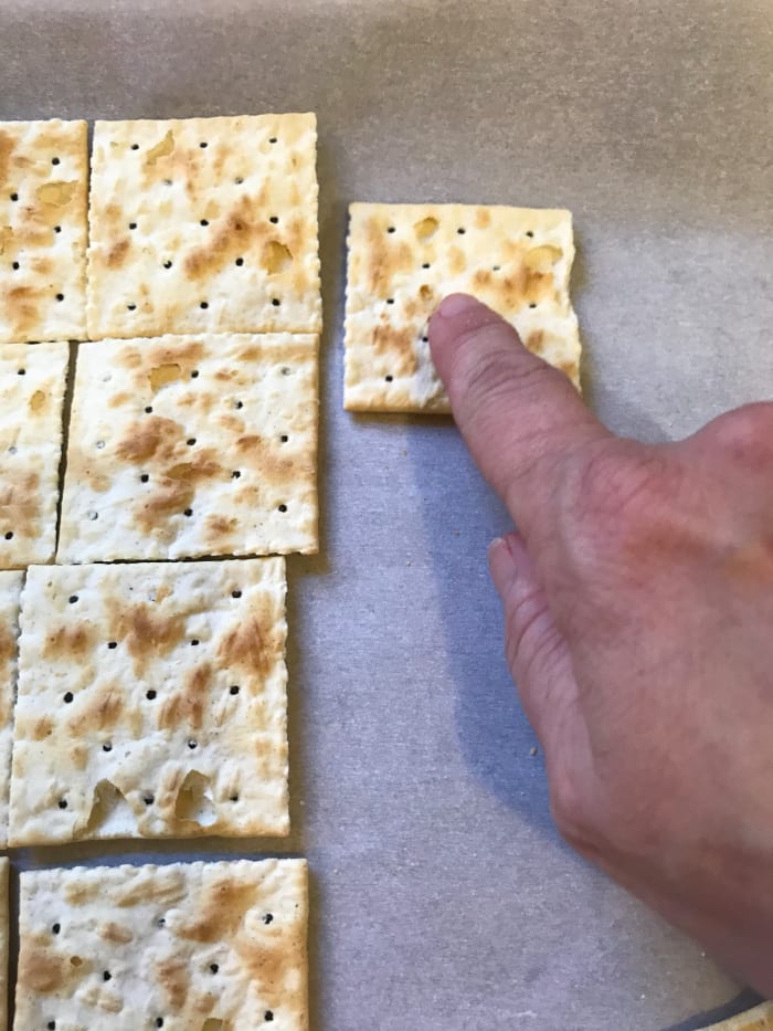 On a parchment lined baking sheet, lay out the saltine crackers. Keep them touching but not overlapping—although in all honesty, they'll wiggle out of place when you pour on the toffee and then bake. No problem. This is easy stuff.