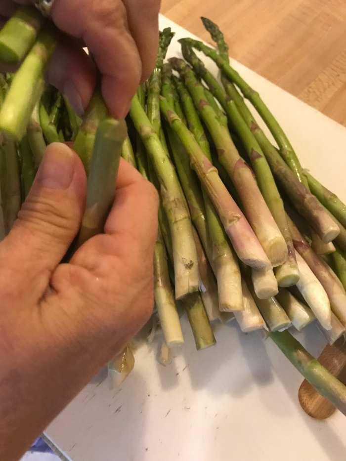 Prepping asparagus is a snap - literally! Hold the spear close to the root end and bend - it will break at the right spot - about an inch or so up. You can also trim them with a knife if you'd like.