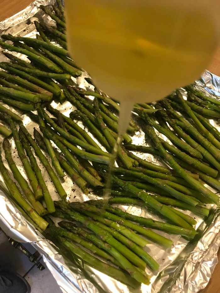Lay the asparagus in a single layer on the baking sheet and drizzle with a little olive oil. It only needs a couple of teaspoons- too much and the finished asparagus will be greasy and oily. Just a little is all you need.