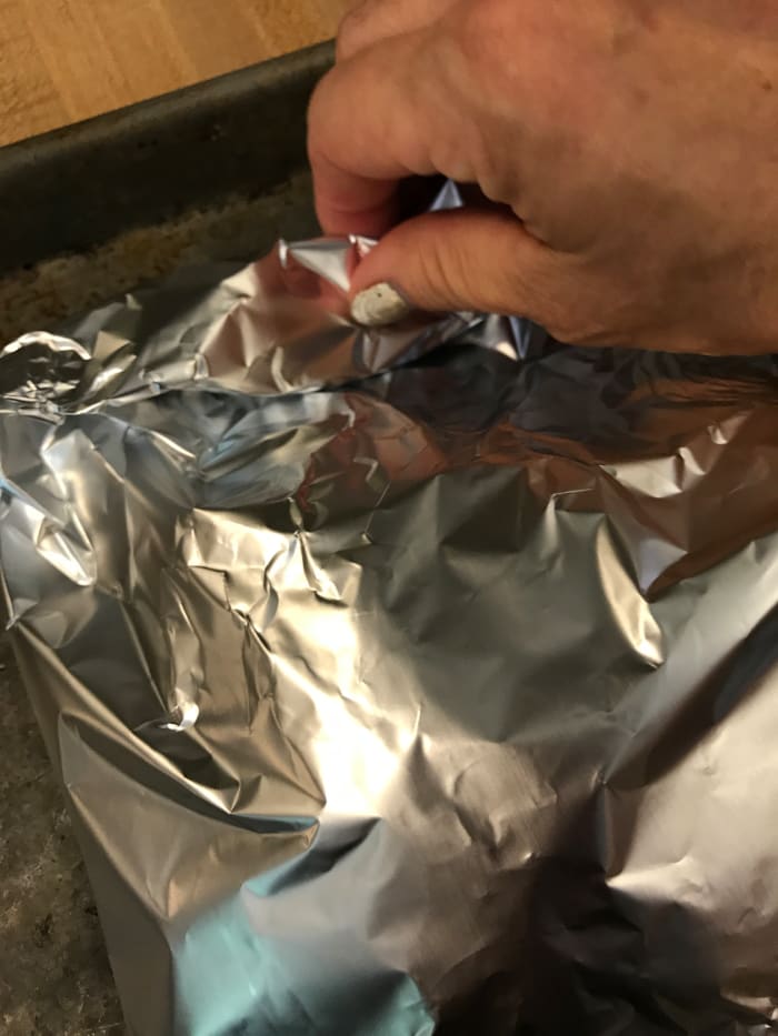 If you use parchment paper, fold up the edges and wrap a couple of times, or use butcher's twine to make a 'purse'. With foil, simply roll and crimp the edges to seal the packet.