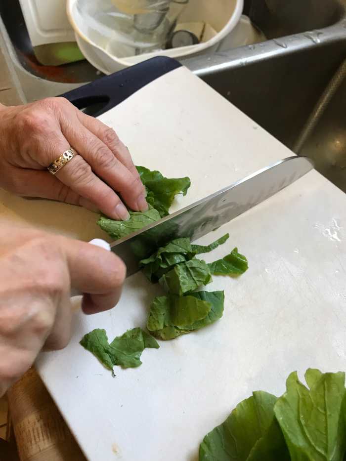 Once rolled, cut each stack of leaves into ribbons by slicing the roll into about 1/2 inch slices. You can also simply tear the leaves into small pieces, but I think this is just as fast and makes a nice, consistent finished dish.