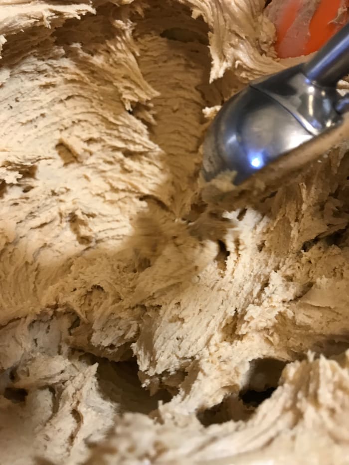 You know the candy is right if you can scoop it easily, and if you can roll the balls like meatballs without them falling apart. If they aren't stiff enough, they'll fall apart. So add more powdered sugar until you get that consistency.