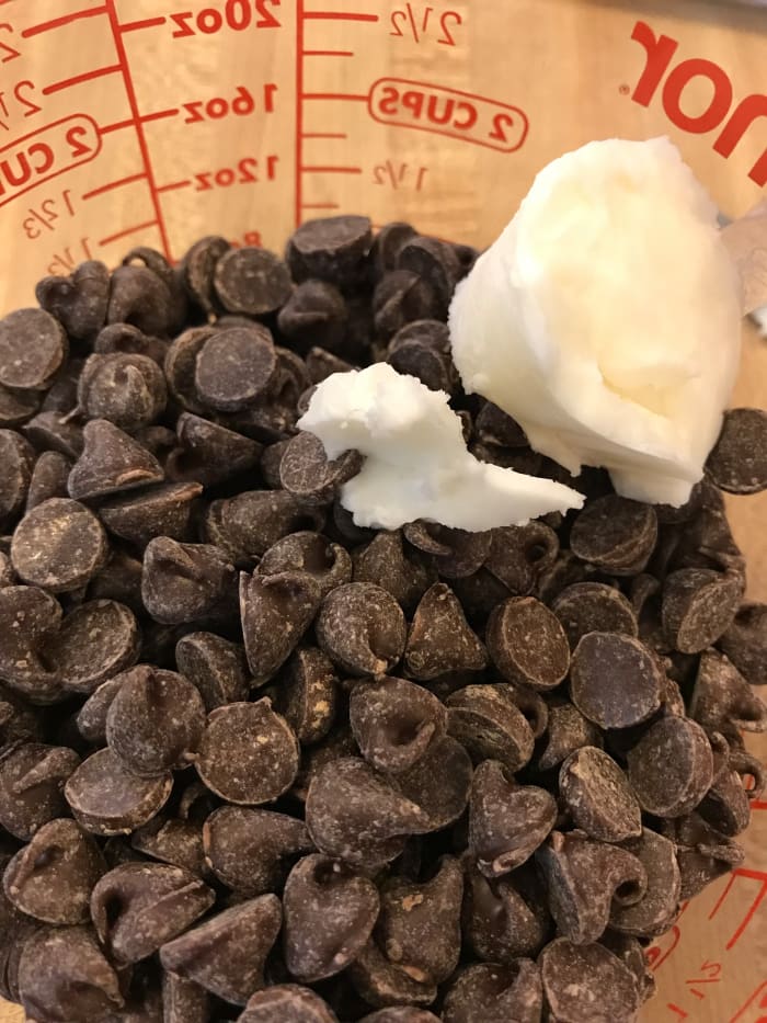 Using a little shortening while melting chocolate makes it melt a bit more easily, helps keep it from seizing, and makes it easier to use for dipping. Just zap it in the microwave for a few seconds at a time.