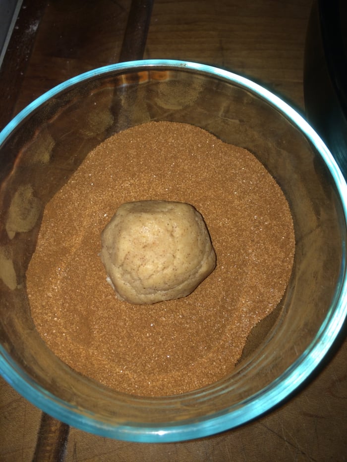 Roll cookie dough balls into the cinnamon sugar mixture, completely coating the cookie dough balls.