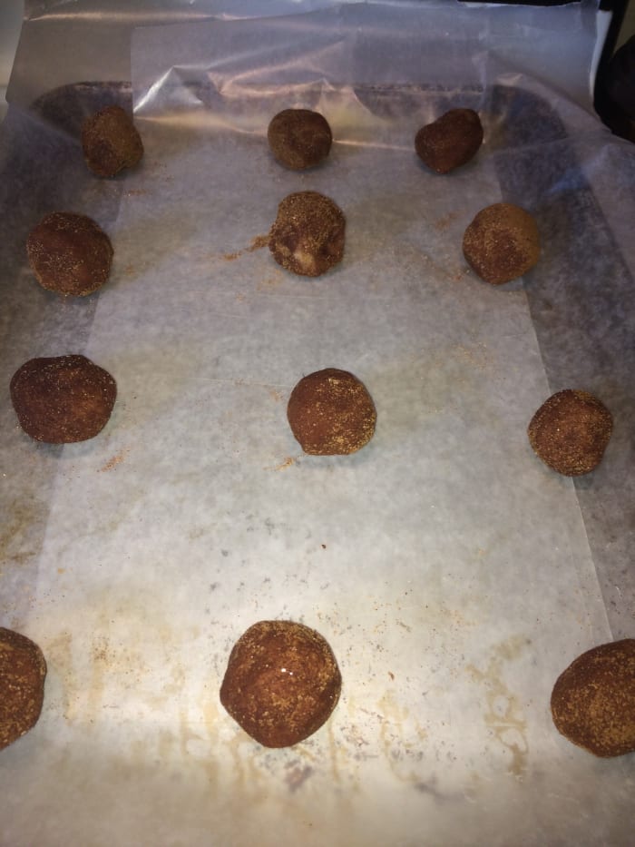 Place cookie dough balls on an ungreased cookie sheet 2 inches apart. Using baking sheets or pan lining paper is fine. Be sure not to grease the pan otherwise the underside will likely burn.