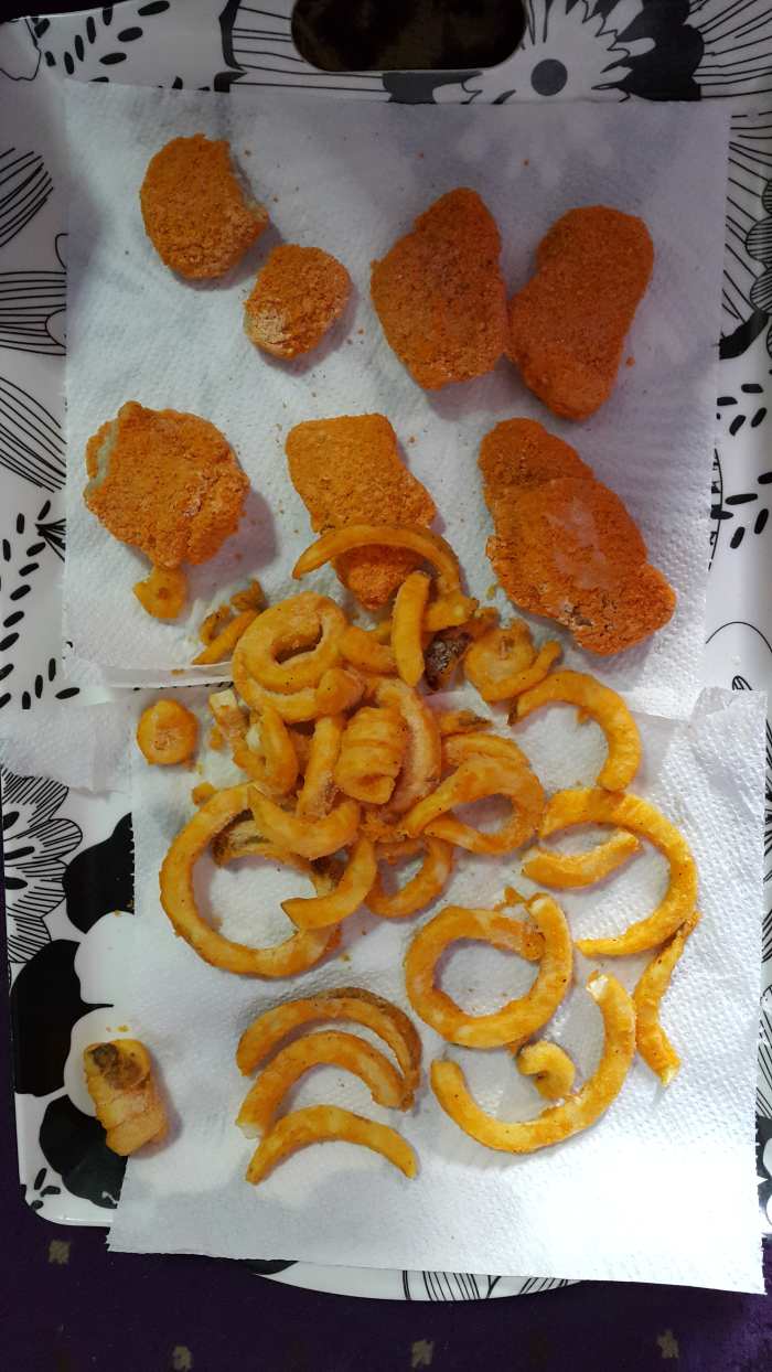 Before frying, spread the chicken nuggets and curly fries on an absorbant paper towel/tissue paper.