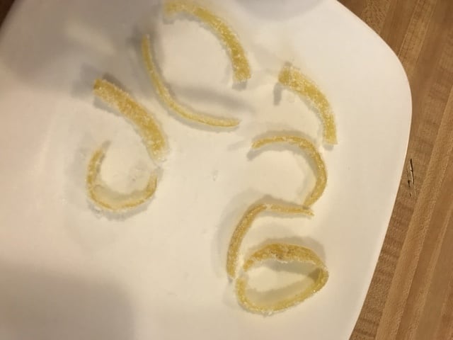 Remove the excess sugar by shaking it gently, and lay the candied lemon peel out to dry. It should only take a couple hours for them to firm up and be ready.