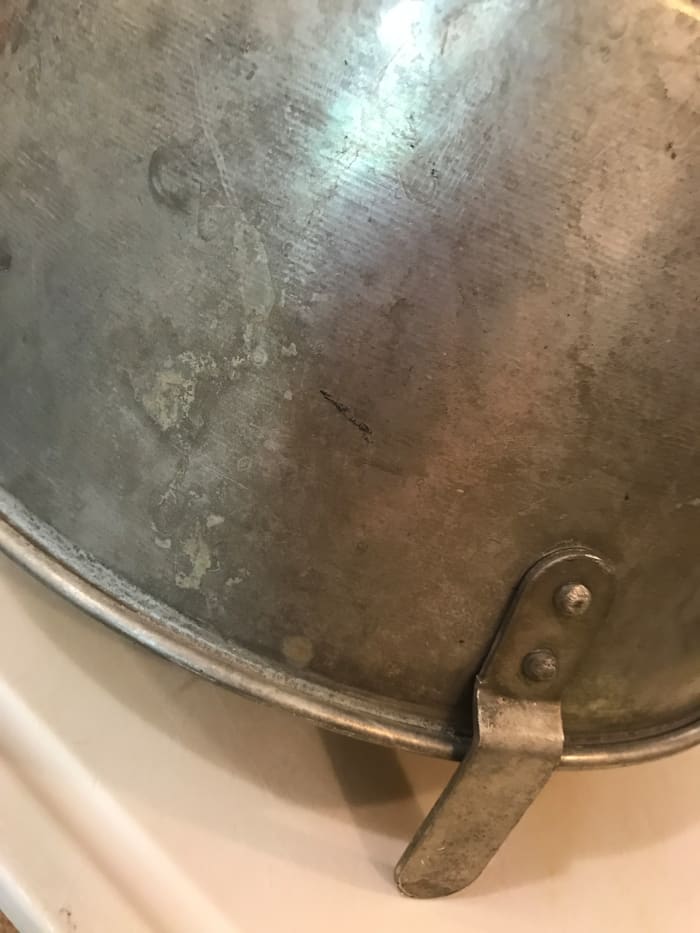 Most tube pans come with little extensions that are for this very purpose - to cool a cake upside down. This helps keep the volume high - it doesn't deflate as it cools. Use gravity to help you out!