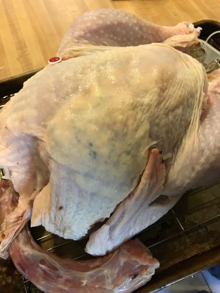 Work the butter under as much of the skin as possible. It helps to press on the top of the skin to spread it out.
