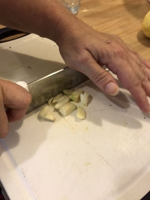 You can use a garlic press - that makes minced garlic super easy to do. Or use a chef's knife and mince by rocking the knife back and forth over the garlic several times - in one direction then back in the other.