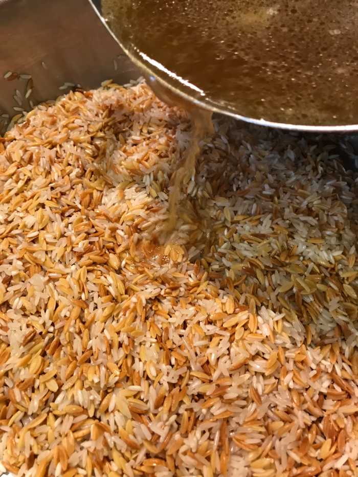 Add the hot broth to the rice and orzo. Stir it and then cover. Set a timer for 15 minutes - this is plenty of time to cook the rice and to allow the liquid to fully absorb.