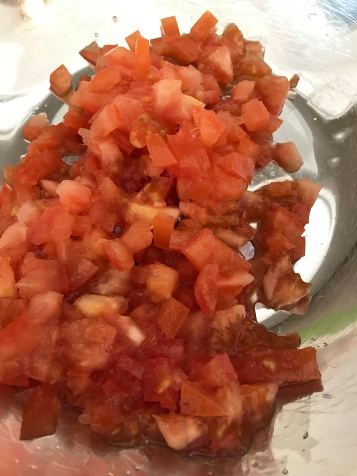 I like the texture of fresh Roma tomatoes, and they tend to have a lower moisture content than other varieties, so they 'weep' less in the finished guacamole.