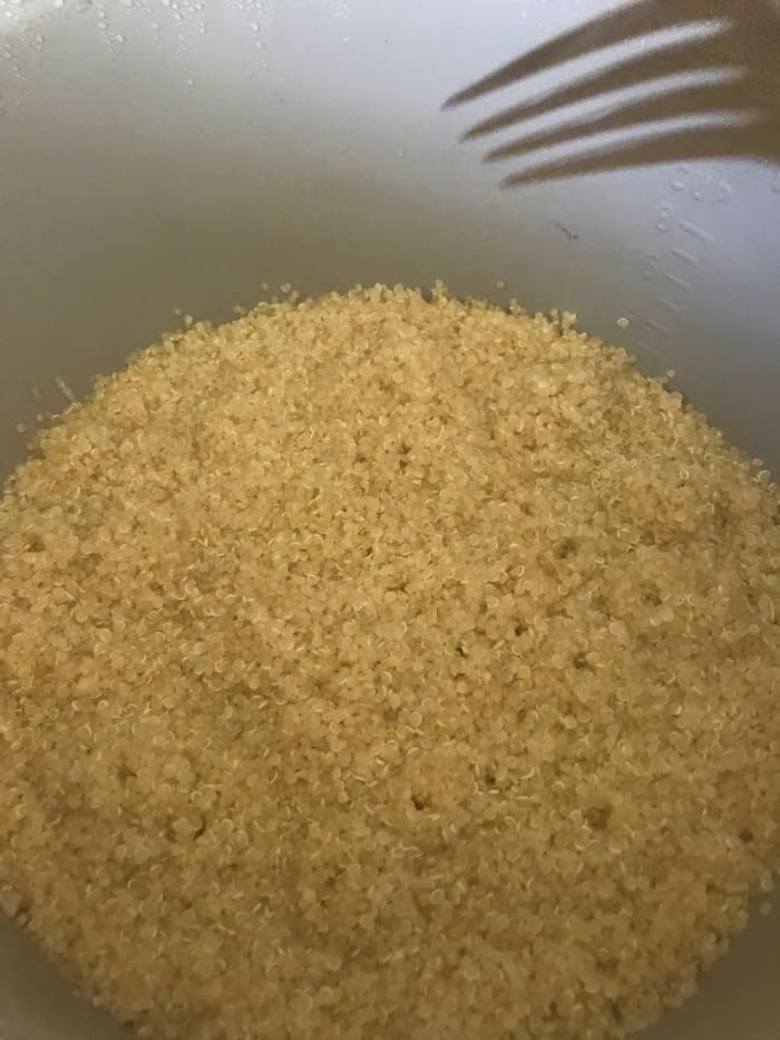 Fluff the cooked quinoa with a fork to separate the individual grains. Don't squash it with a spoon or spatula - you'll compress the cooked grains and get a bit mushy.