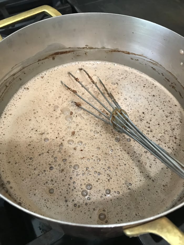 Combine the sugar, half and half, milk and cocoa in a saucepan over medium heat. Bring up to a bare simmer, whisking well to fully combine. Don't let it actually boil - a mere simmer is perfect.