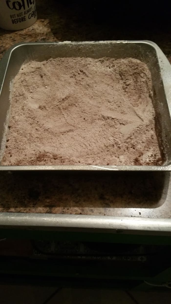 In an 8-inch greased baking dish, combine and mix together the flour, baking cocoa, sugar, baking soda, and salt.