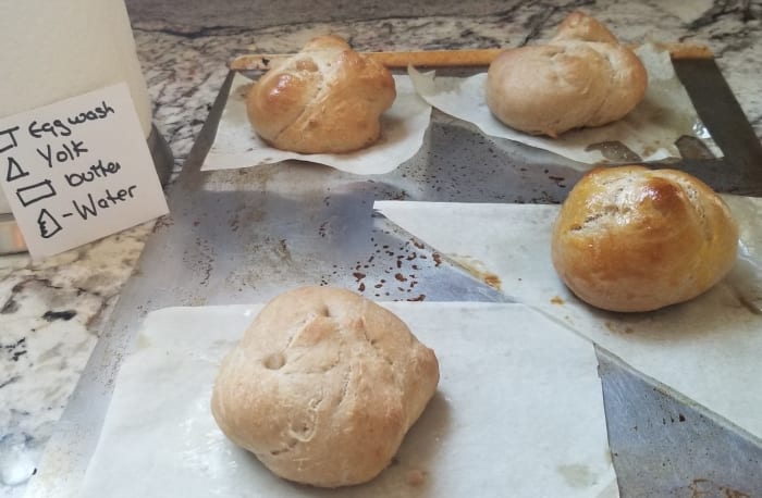 The water glazed and roll brushed with butter are not nearly as shiny as the rolls topped with egg. The yolk topped roll is the darkest, but they were all baked at the same temperature for the same amount of time.