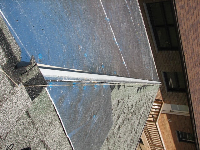 the reverse J Trim is run on top of the foil covered foam sheeting...this is where the ridge cap will be anchored when the steel roofing panels are all in place