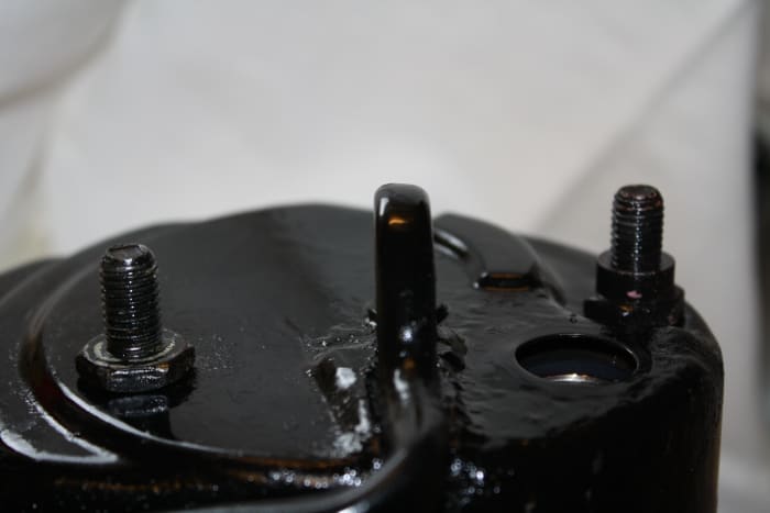 Bracket studs. Notice one has a higher shoulder to compensate for the recess in the reservoir cover that allows the bracket to mount level. Don't switch the two bolts.