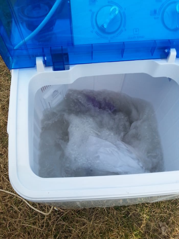 Here's my RV washing machine in action out on the grass. I ran an extension power cord to it, filled it with a garden hose, and watered the dry lawn when draining it!