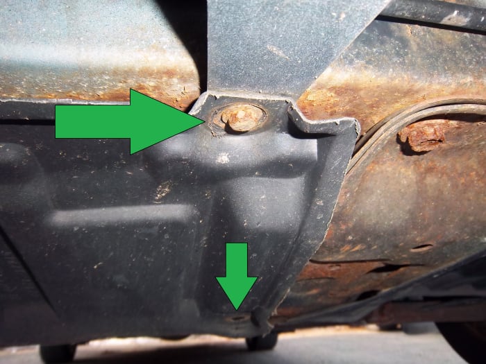 The plastic cover hiding the drain plug and oil filter is held in place by 10-mm bolts. Be careful removing them as they are likely rusty and may strip or break.