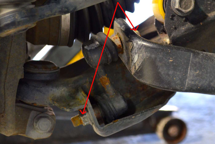 Remove the two bolts highlighted in the photo above with a 17mm wrench. A vise grip may need to be used to prevent turning. Remove old link after nut removal.