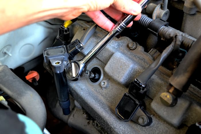 Now with a 5" extension bar and the 5/8" spark plug socket, fit the socket over the plug and turn left to loosen. Continue loosening until the plug is free, it should be stuck in the socket and easily removable.