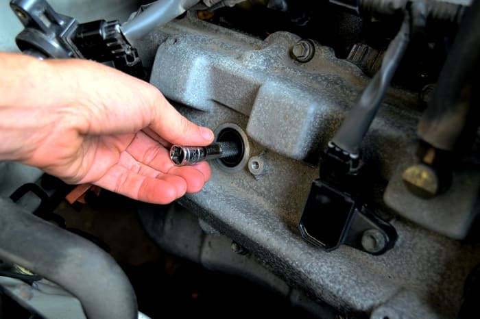 Thread the spark plug in by hand until hand tight. Use the ratchet to torque the plug in by turning 1/2 a turn past hand tight. If using a torque wrench torque to 13 ft lbs.