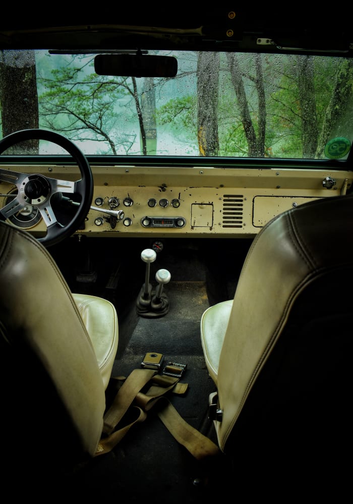 A sparse interior with only the addition of a twin-stick transfer case shifter and an aftermarket steering wheel soon-to-be replaced by an original.