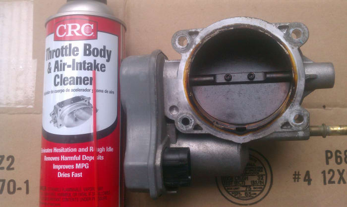 The cleaner and the throttle body removed from the Chevy. Notice the plastic casing next to the cleaner. This hold the sensors and valves, making them inaccessible.