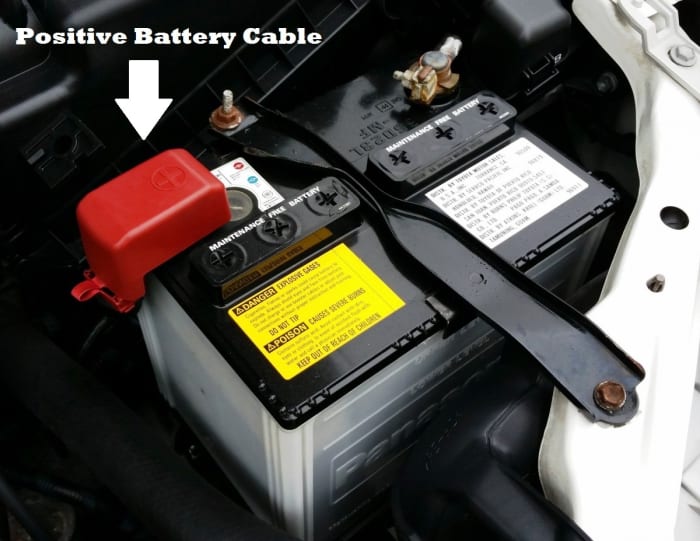 Remove the red rubber boot (if present), then loosen the battery cable clamp with a wrench. This will allow you to remove the positive battery cable.