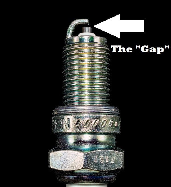 Set the gap of the spark plug by bending the right angled metal piece at the end to the appropriate distance using a gapper tool.