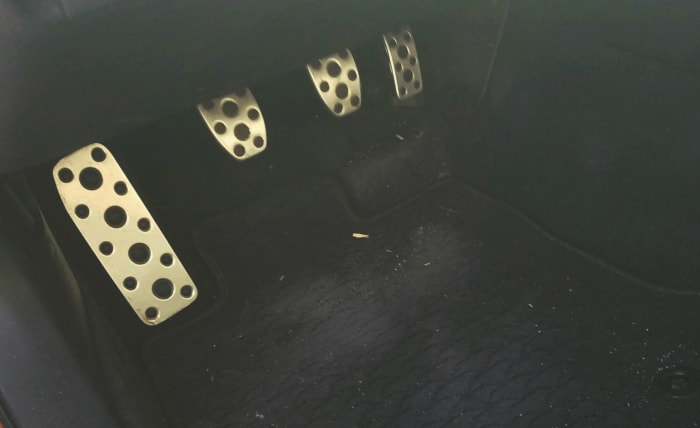 The far left is not a pedal, it's a resting place for your foot while driving. The clutch pedal is second from the left. The brake is next and the gas is on the far right.