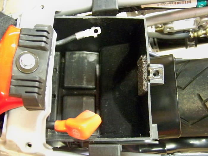 Remove the battery cables from the battery terminals. This is a safety precaution to make sure the motorcycle is completely inert. Then remove the battery.