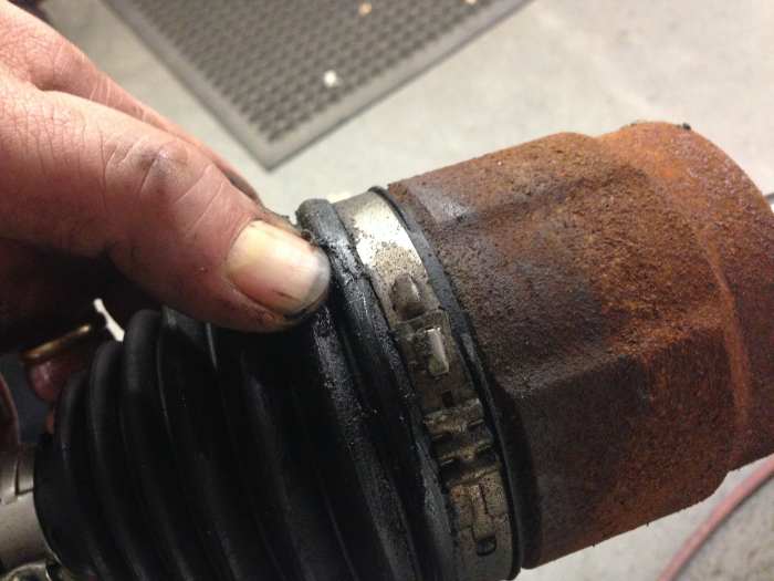 Here you see an inner CV joint boot split near the cup, causing grease to leak from the joint.