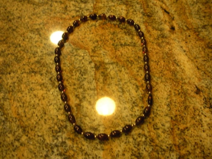 Oh, how ugly this looks! Not only can you see the ceiling lights, but the background is a very poor contrast to the necklace
