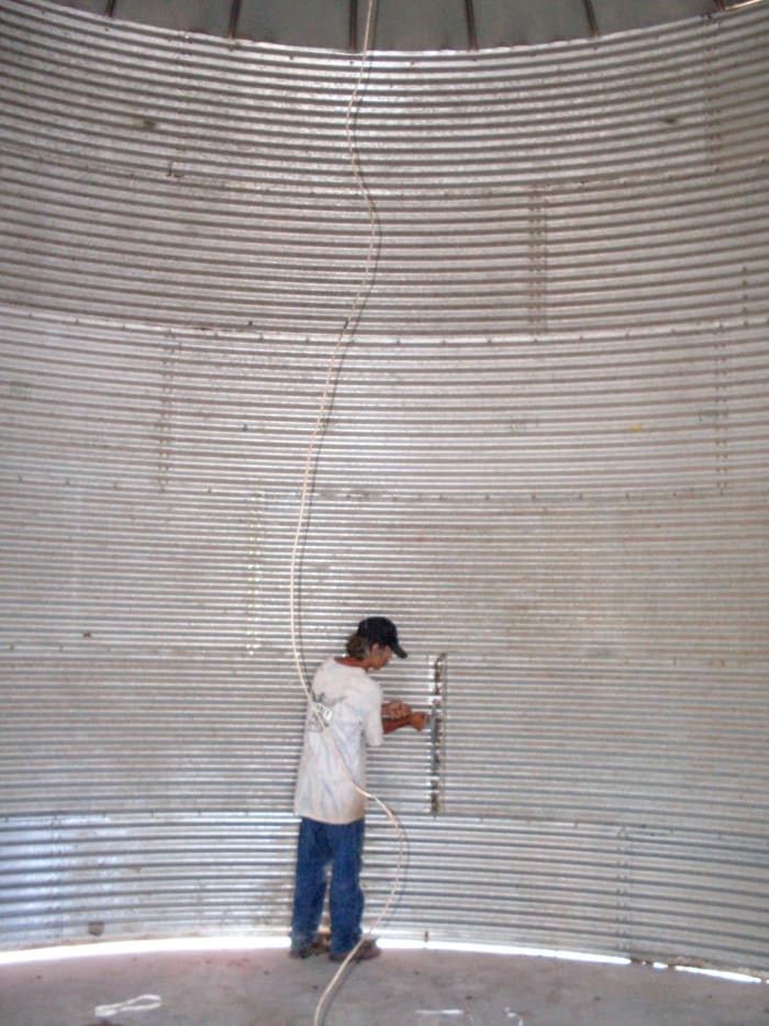 Hubby hard at work on stiffeners, which are bars that help the bin hold up against the thousands of pounds of grain without buckling.