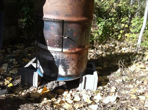 Set some non-combustible blocks under your incinerator. You could use steel or ceramic or brick as long as it can not ignite.