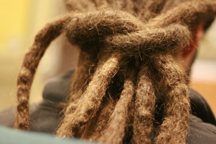 People wear dreadlocks for both religious and non-religious reasons. Members of the Rastafarian sect often wear dreadlocks and untrimmed beards. Employers may pressure them to comply with company dress codes.