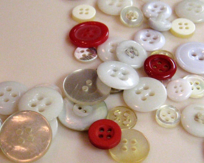If you have a lot of buttons, sort them by color into different pill bottles. Write the color on the side of the bottle or put a label on it.