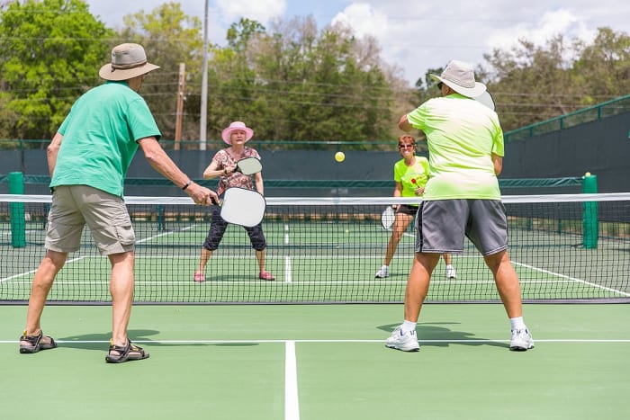 A doubles game of pickle ball, a sport popular with retirees in many gated communities. Many gated neighborhoods provide extensive and well maintained leisure facilities.