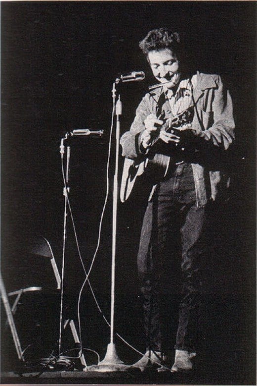 A young Bob Dylan performing at St. Lawrence University in New York. Dylan began his career playing solo on an acoustic guitar. It caused great controversy when he switched to an electric instrument and got a backing band in folk circles.