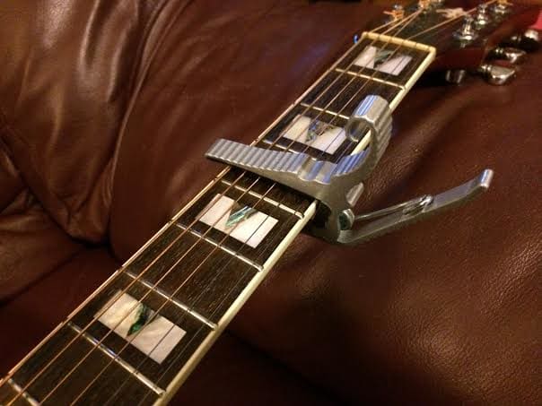 A capo is a great way to make those ridiculous barred open chords easier for small handed guitarists