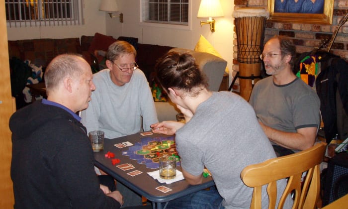 Three brothers and a nephew playing Settlers of Catan. Originally a German game, it won game of the year the same year my now-deceased brother introduced it to us in 1995.