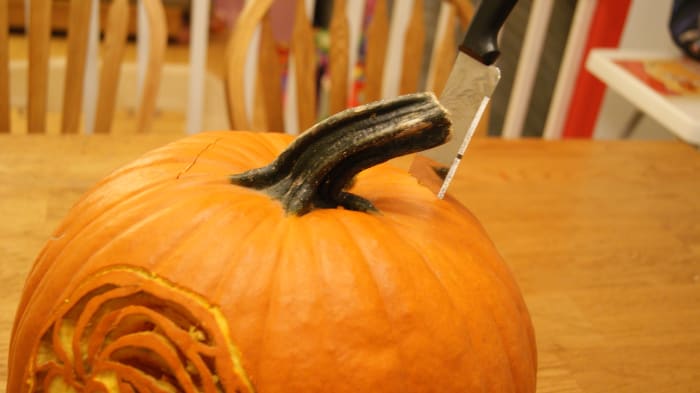 When cutting the lid of a pumpkin go in at an angle to the pumpkin and make the cuts an odd shape