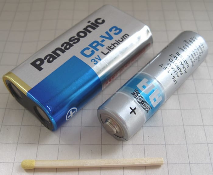 CRV3 3 volt non-rechargeable lithium battery alongside an AA cell for size comparison.