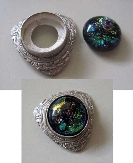 Fine silver bezel wire setting embedded in fine silver metal clay before firing and set with a dichroic glass cabochon after firing.