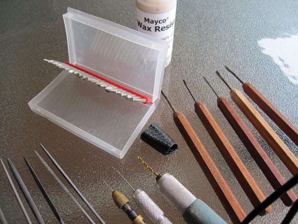 Dockyard micro carving tools, hand drills, diamond burs, needle files, metal-reinforced leather thimble for carving metal clay and Mayco wax resist for water etching. Photo: Margaret Schindel