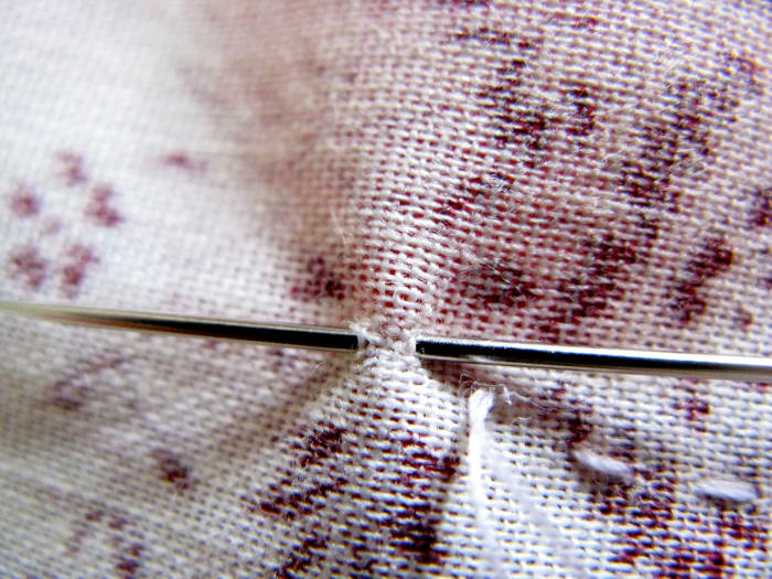 After your final stitch, put your needle part way through as if you are going to do another stitch, but don't pull the needle all the way through.