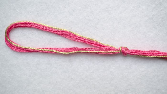 This is what your string should look like after you make the knot at the top. Remember, you should have 11 strings altogether.